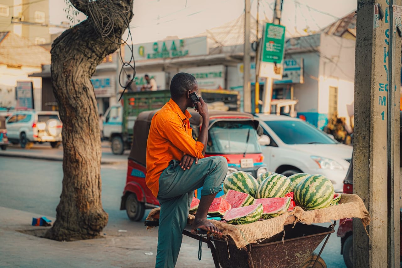 Market trader checking the day's sales on a phone