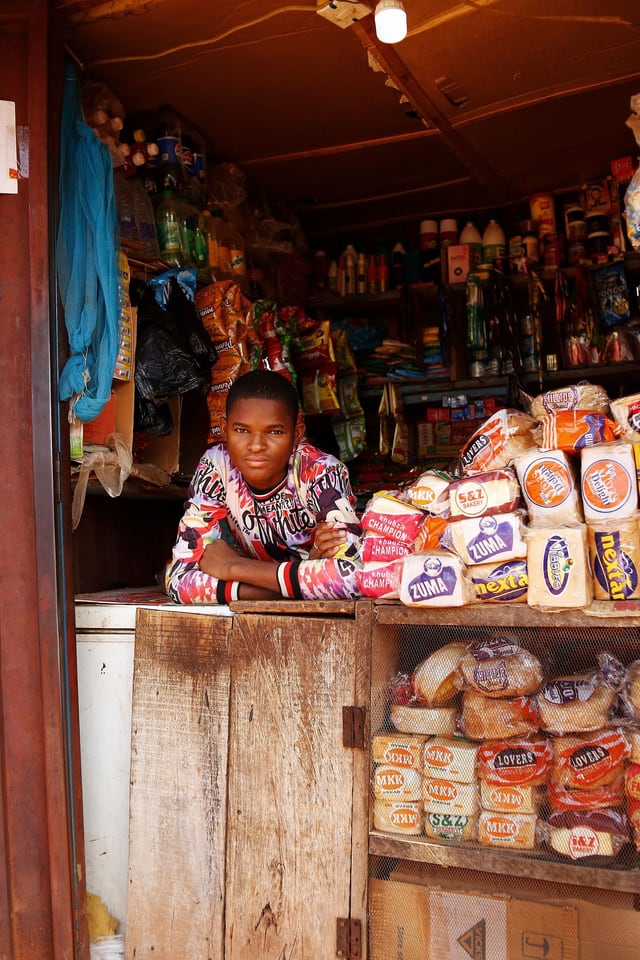 Shopkeeper serving a customer across a shop counter