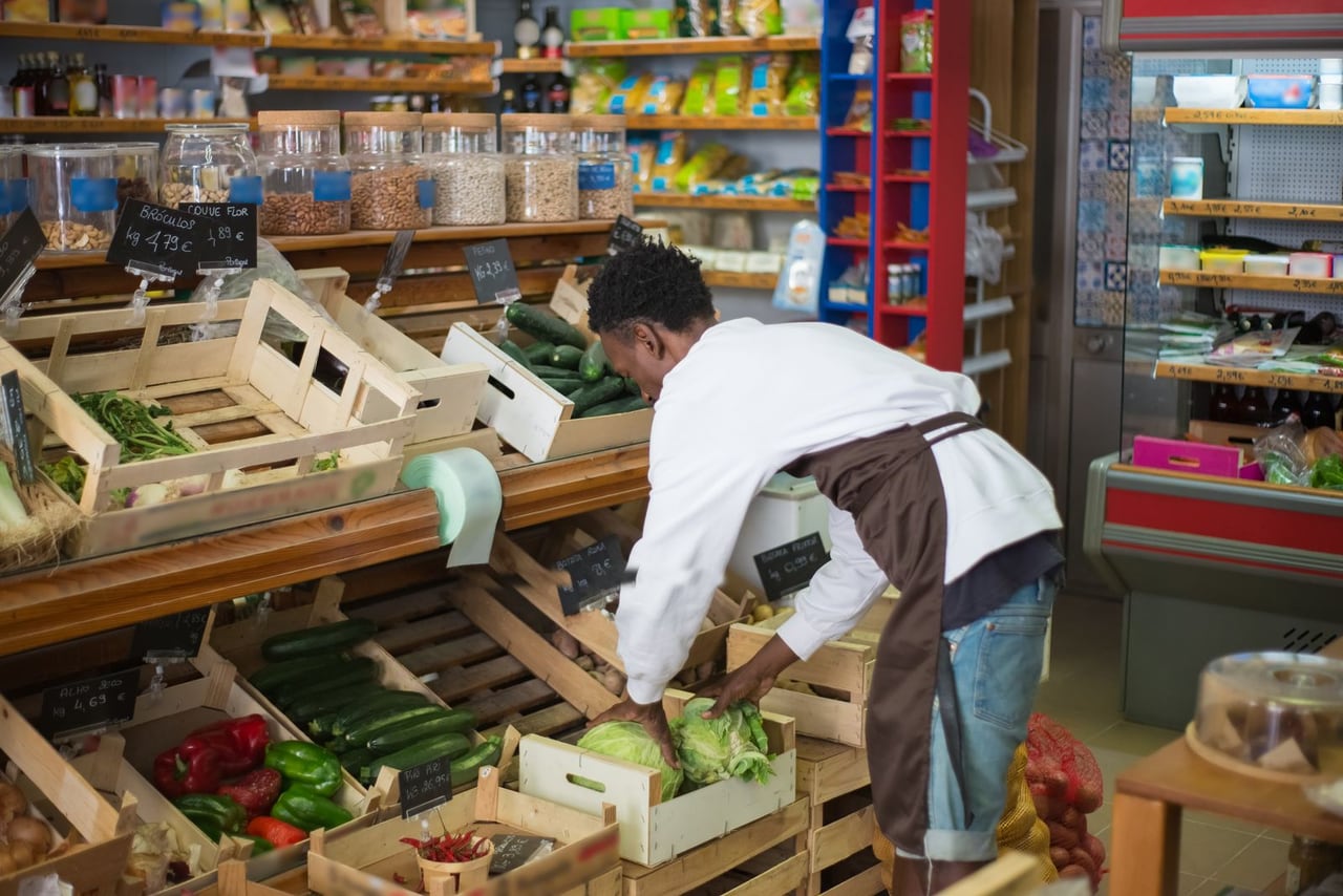 Grocery worker arranging produce